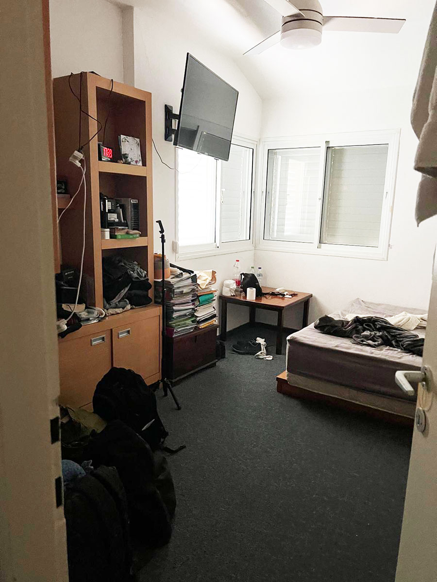 לפני - חדר שינה ישן וצפוף עם ארון, שטיח כהה ושני חלונות לפני פתיחת הסוויטה